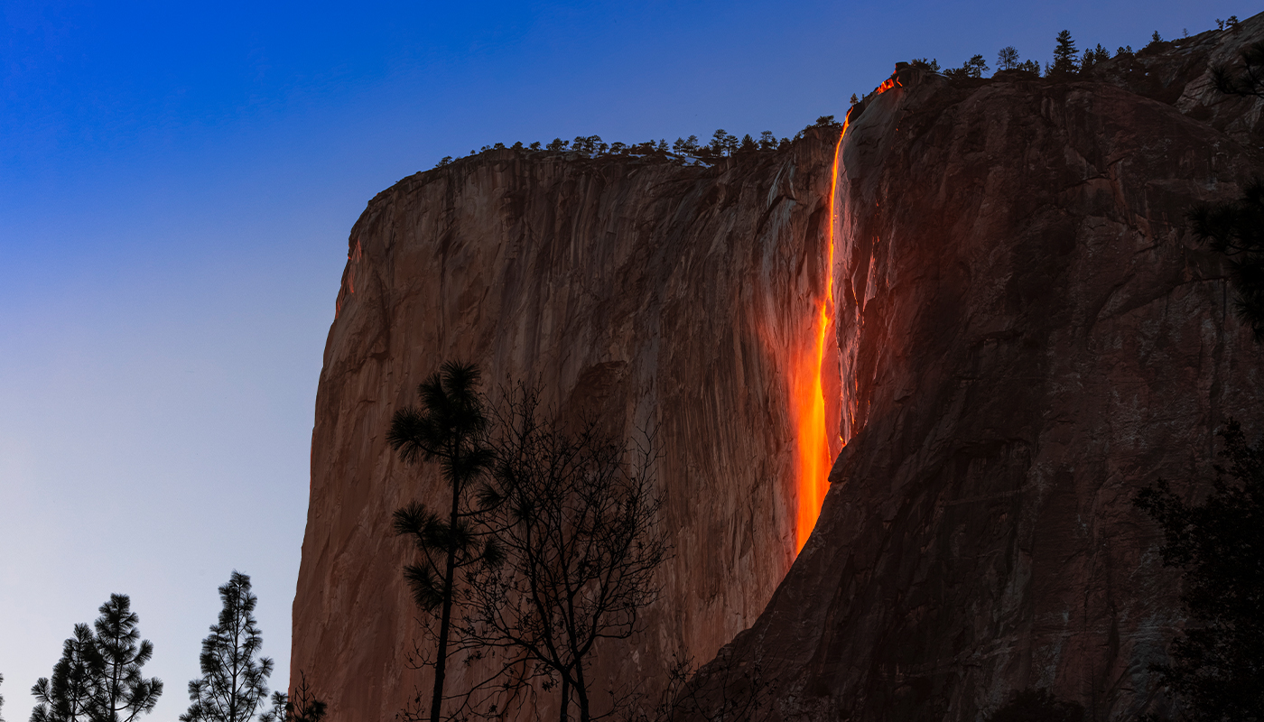 A waterfall at sunset takes on a tinted orange glow. 