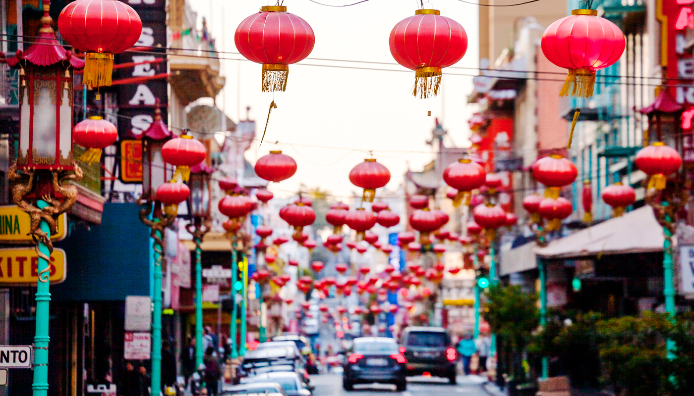 Chinese lanterns hang above a busy street in Chinatown.