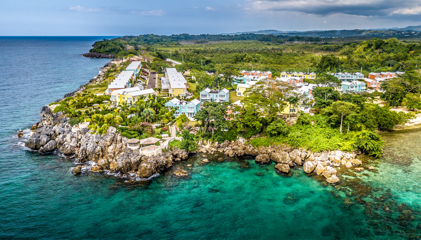 Colorful buildings dot the greenery of this island surrounded by blue waters.
