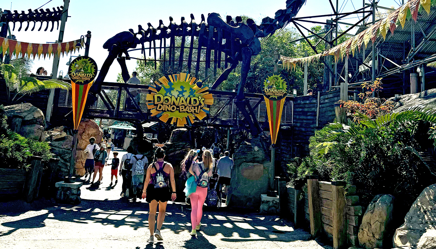 Park guests walk to the entrance of a family-friendly roller coaster