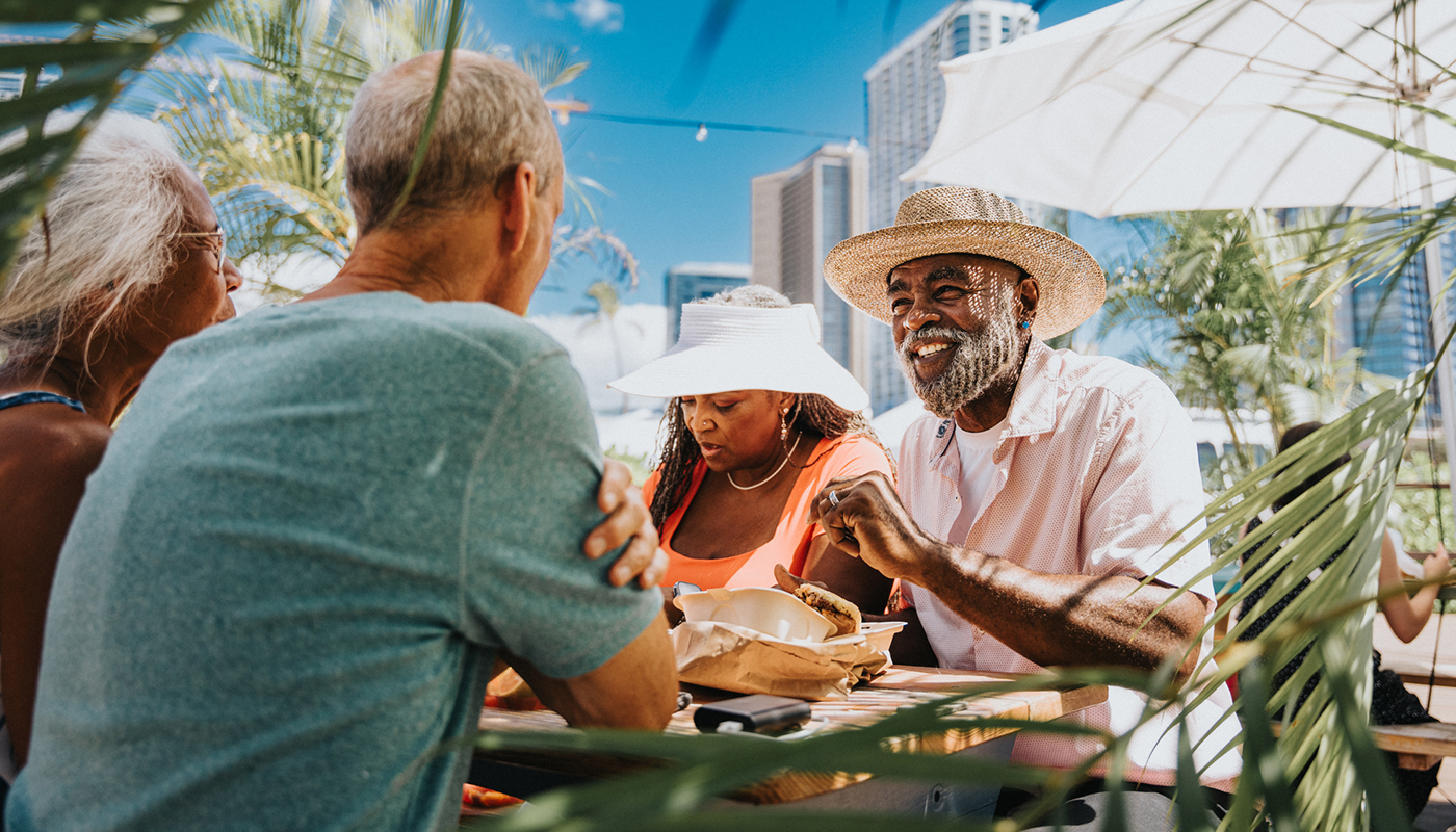 Two couples enjoy lunch al fresco on a sunny day. 