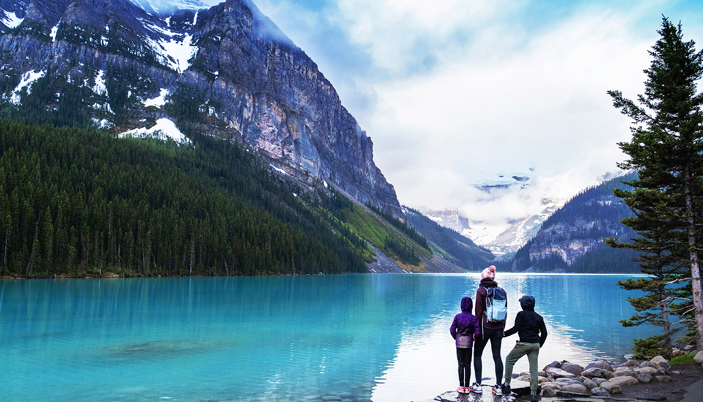 Family hiking around a pristine glacial lake in Banff National Park. Things to do in the National Parks of British Columbia. Hiking trails around Lake Louis