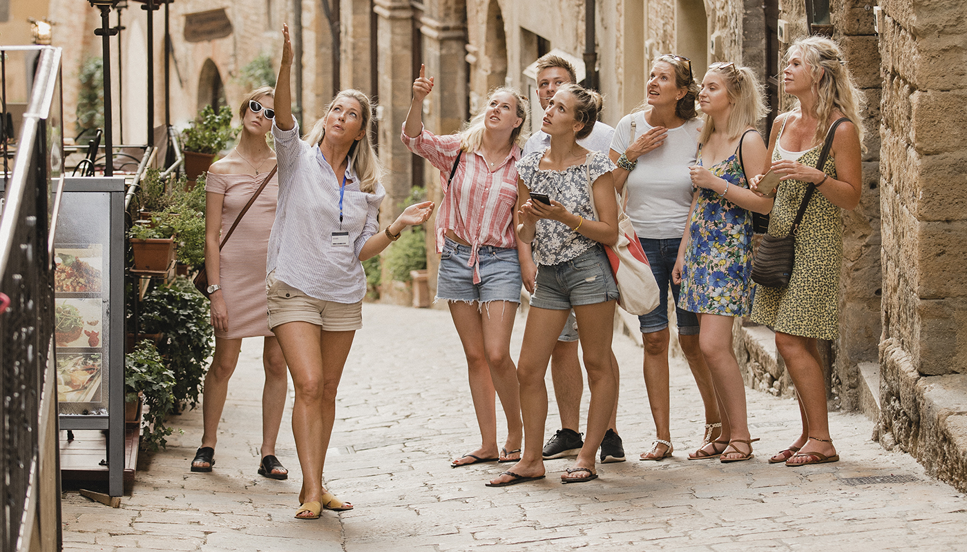 Tour guide leading tourists around Volterra in Tuscany