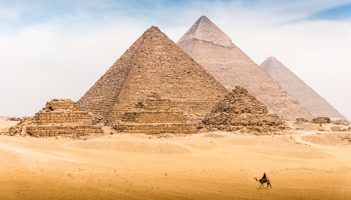 Camel rider with Pyramid complex of Giza, Egypt in the background