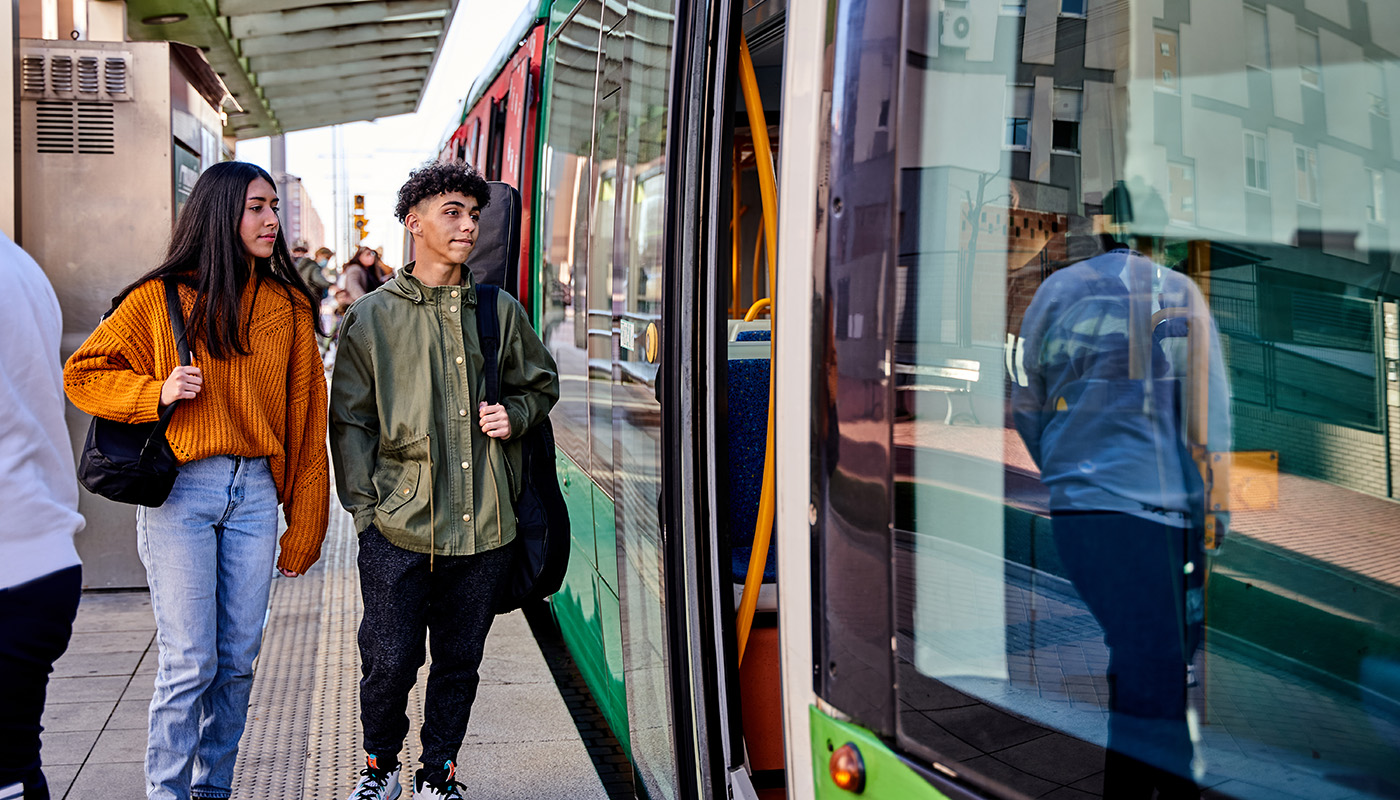 Two young adults entering a tram