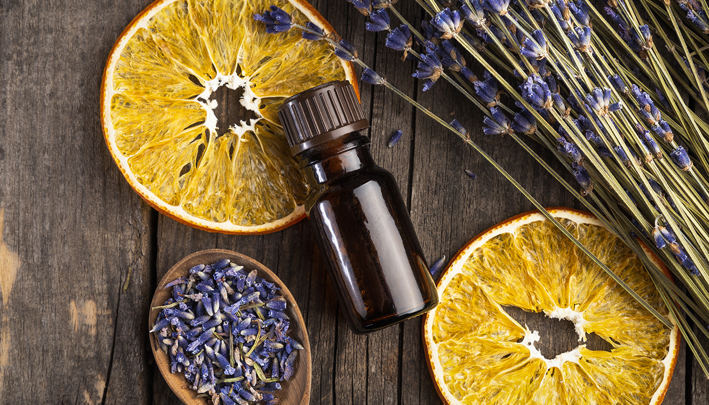 Dried orange slices and lavender with glass bottle of essential oil