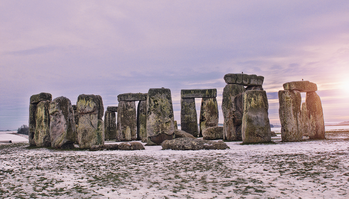 Stonehenge at sunset with a light dusting of snow on the ground