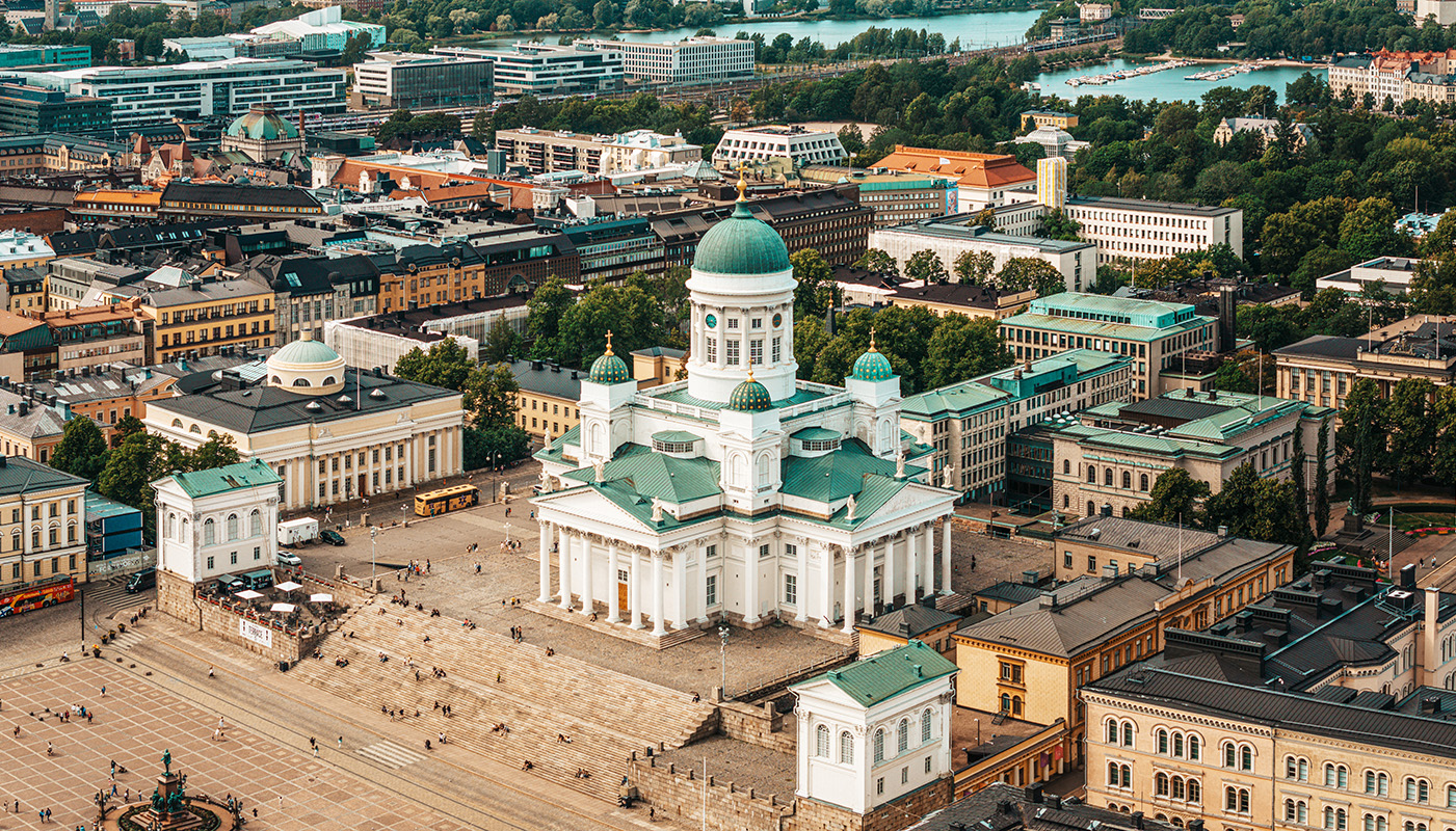 Aerial view of Helsinki with Helsinki Cathedral in the center. Cathedral is white with green roof.