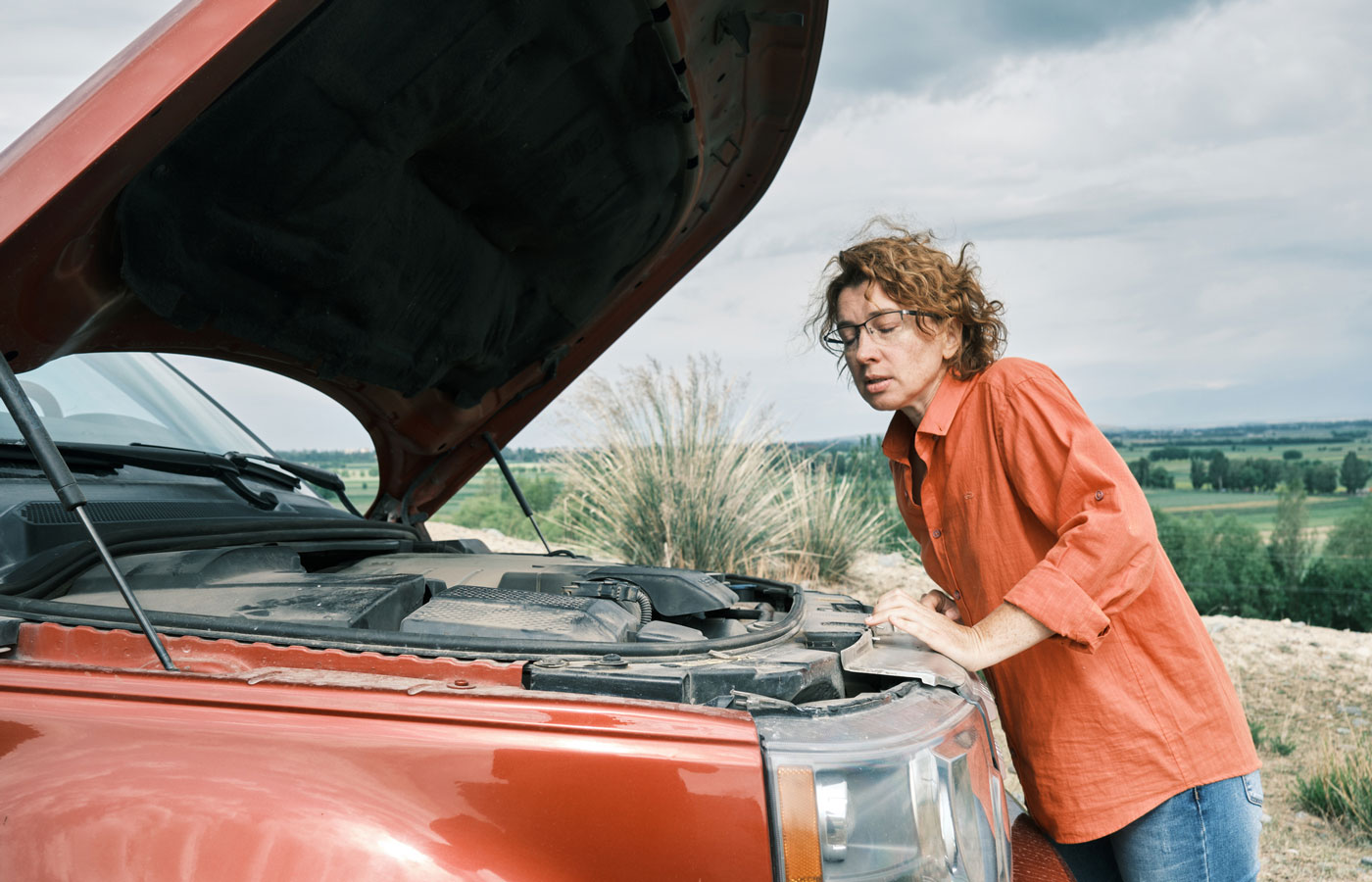 person standing next to truck with hood up