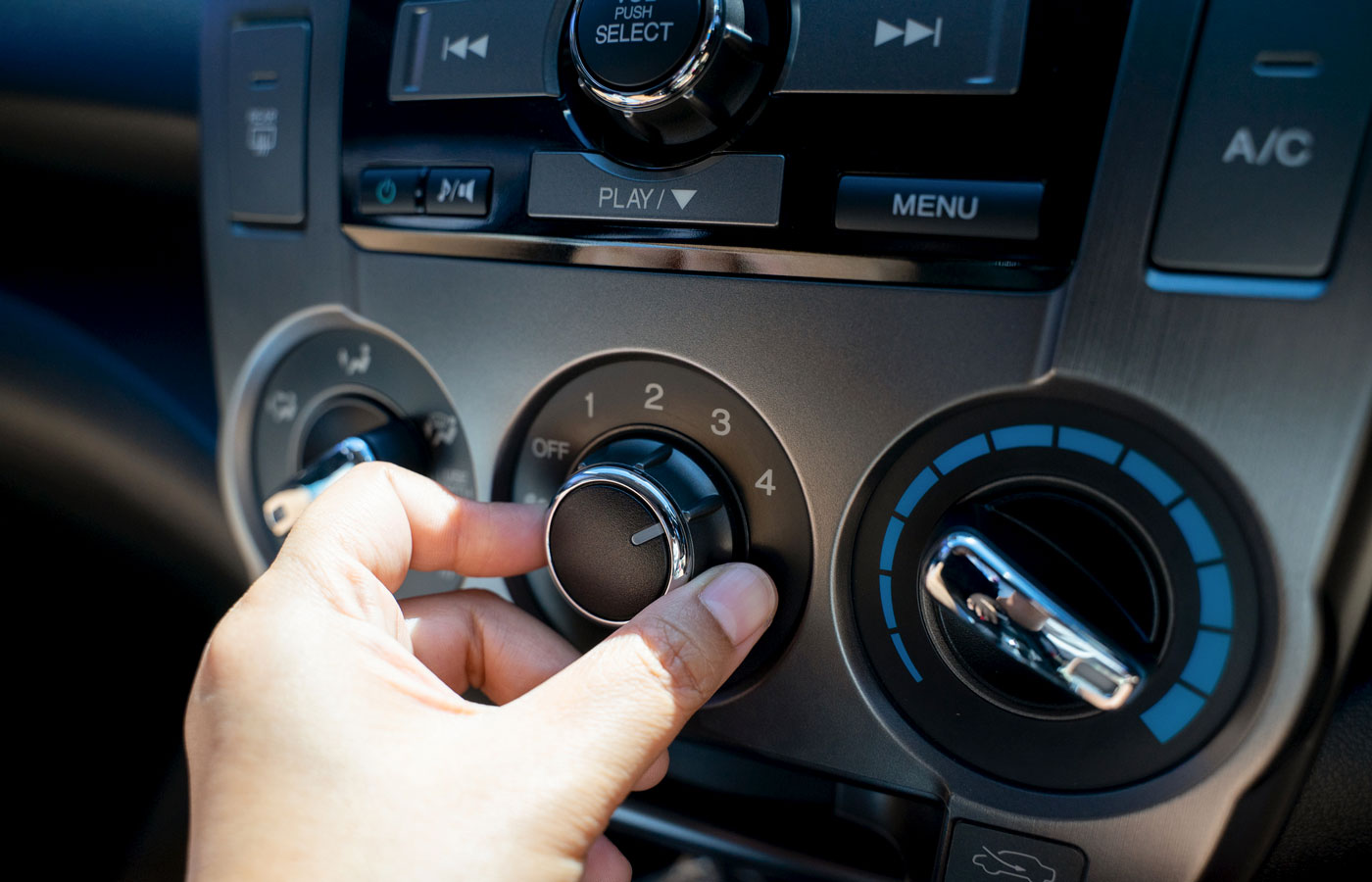 hand adjusting AC in a car