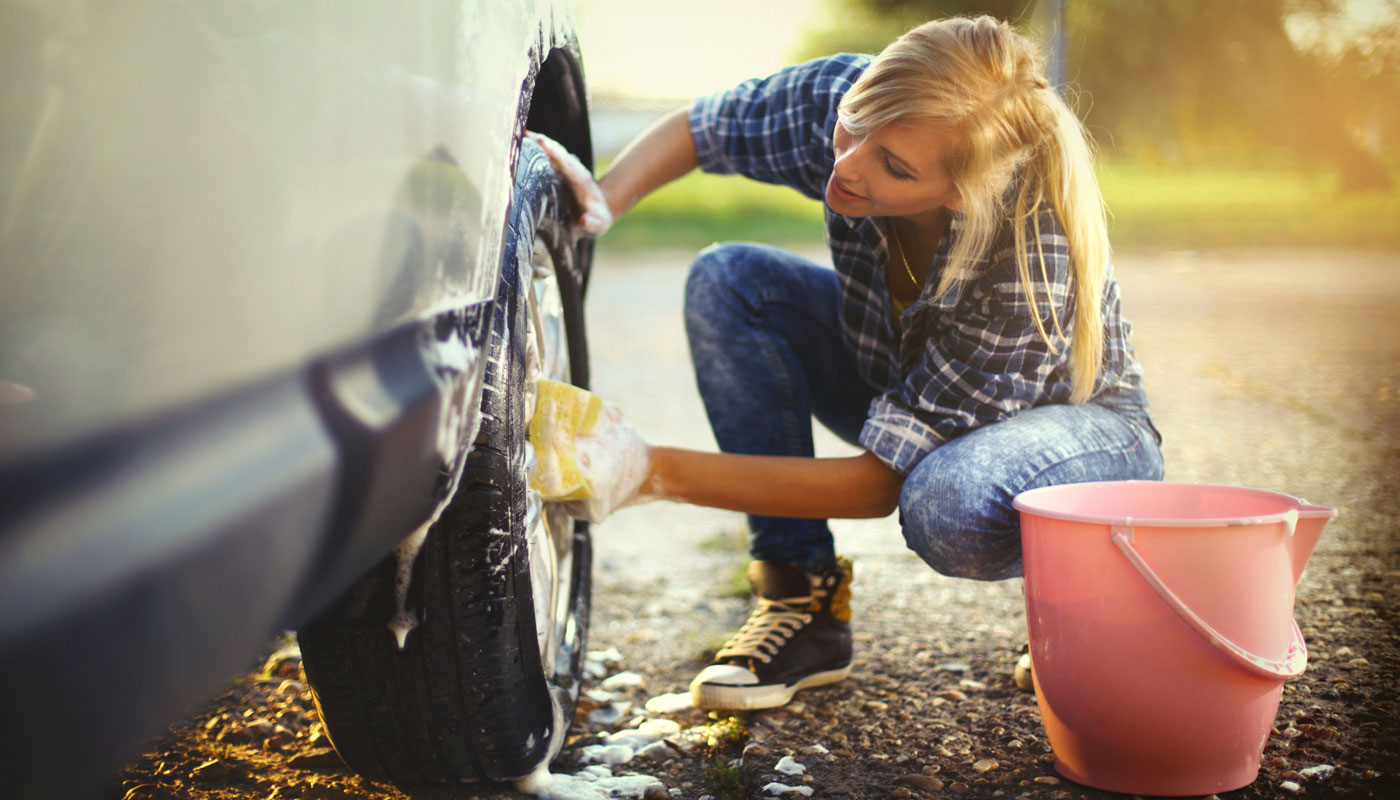 woman washing the tires of her car