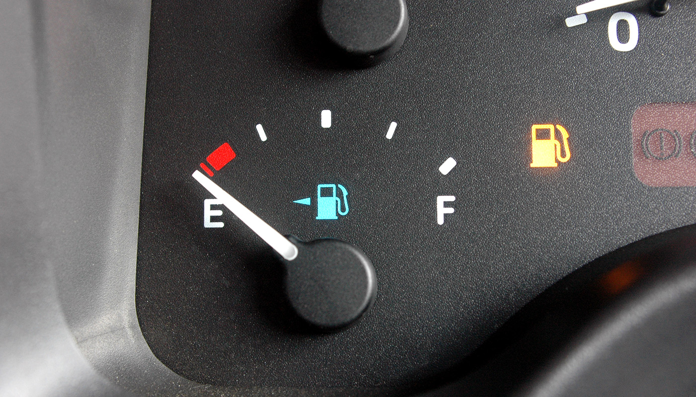 Car dashboard light indicating fuel gauge on empty