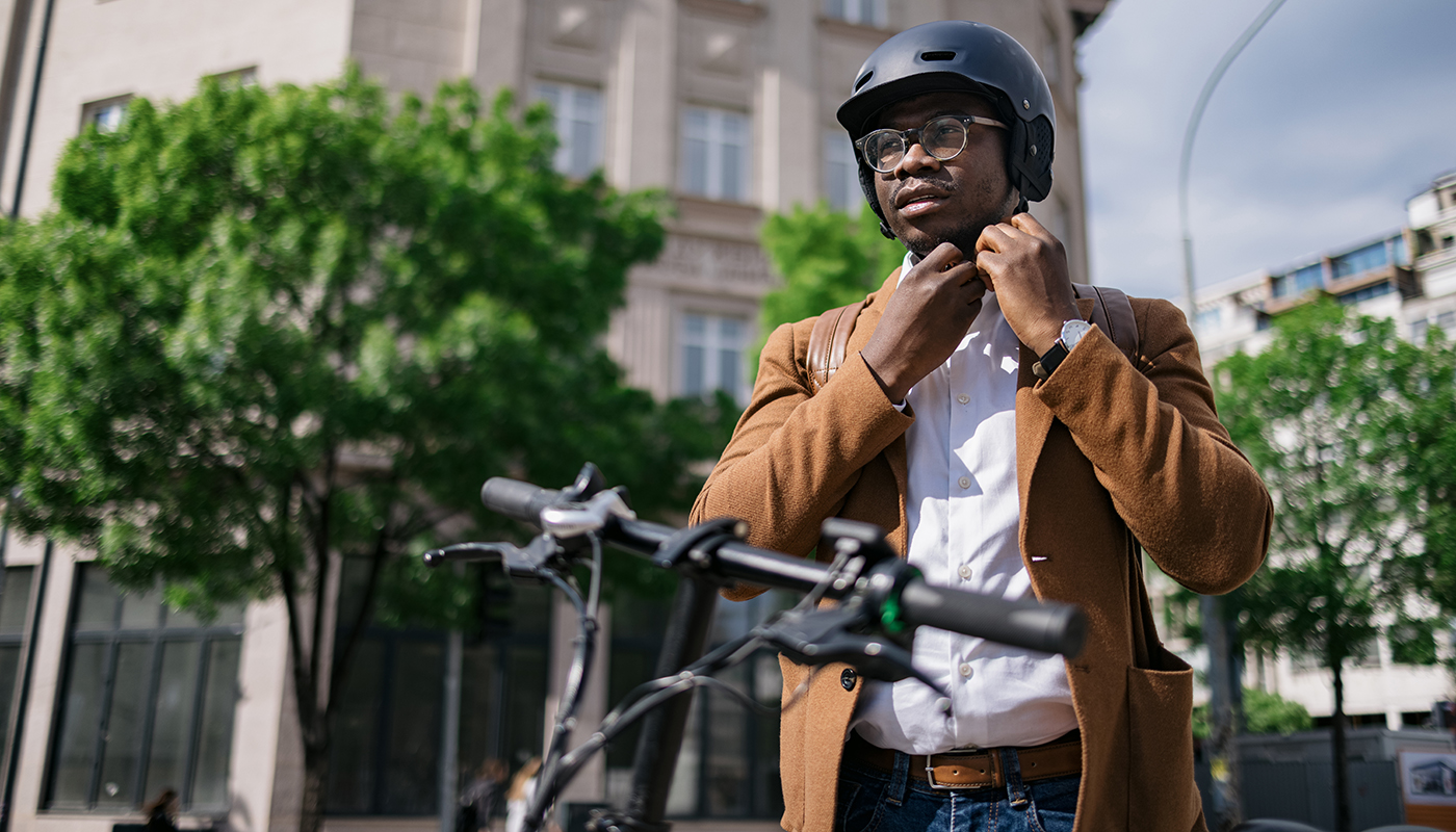 Bicyclist putting on his helmet before riding his bike