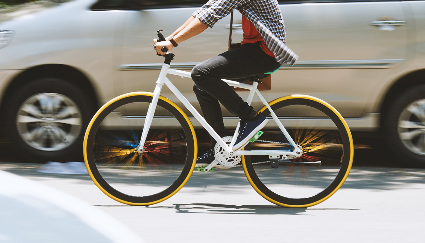 Bicyclist riding parallel to a car