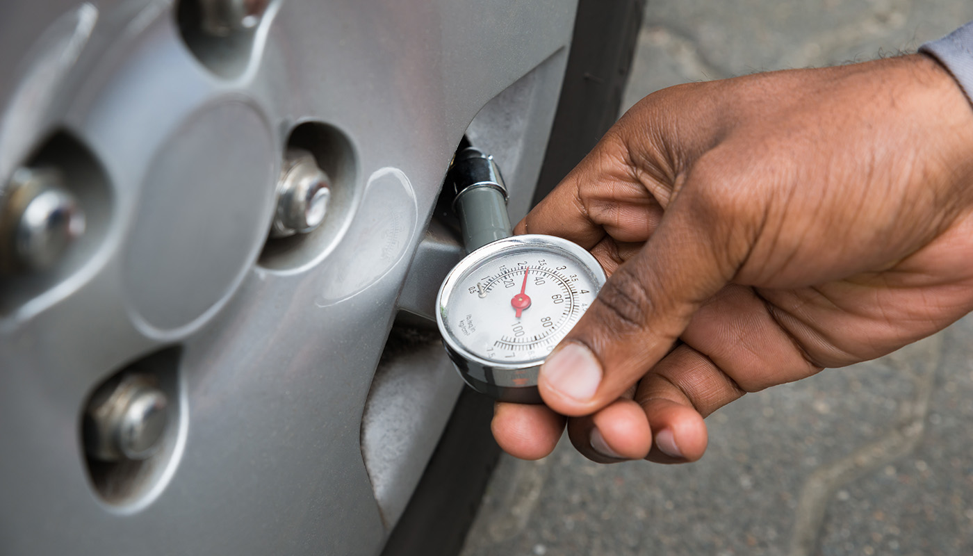 Testing tire pressure with tire pressure gauge