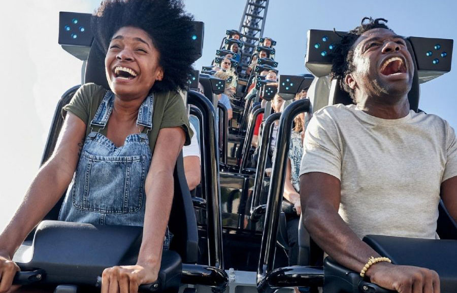 a black man and a black girl riding on a roller coaster
