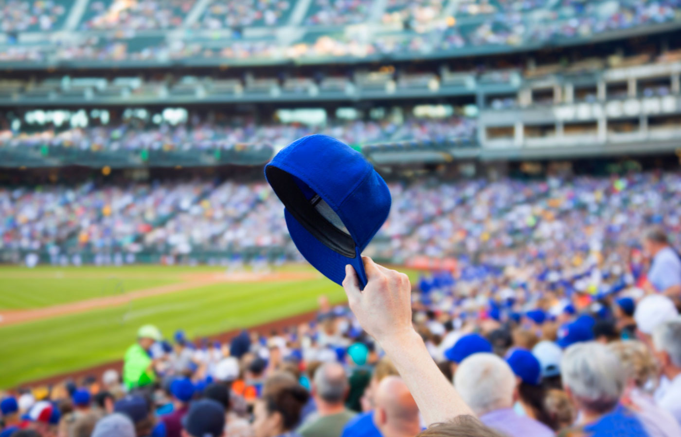 fan holding cap in a baseball game