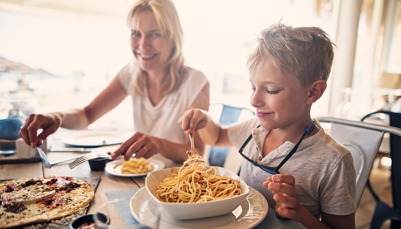 Mother and son enjoying big meal outside on sunny day