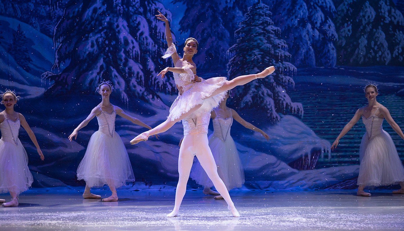 Man lifts woman overhead in ballet performance on stage 