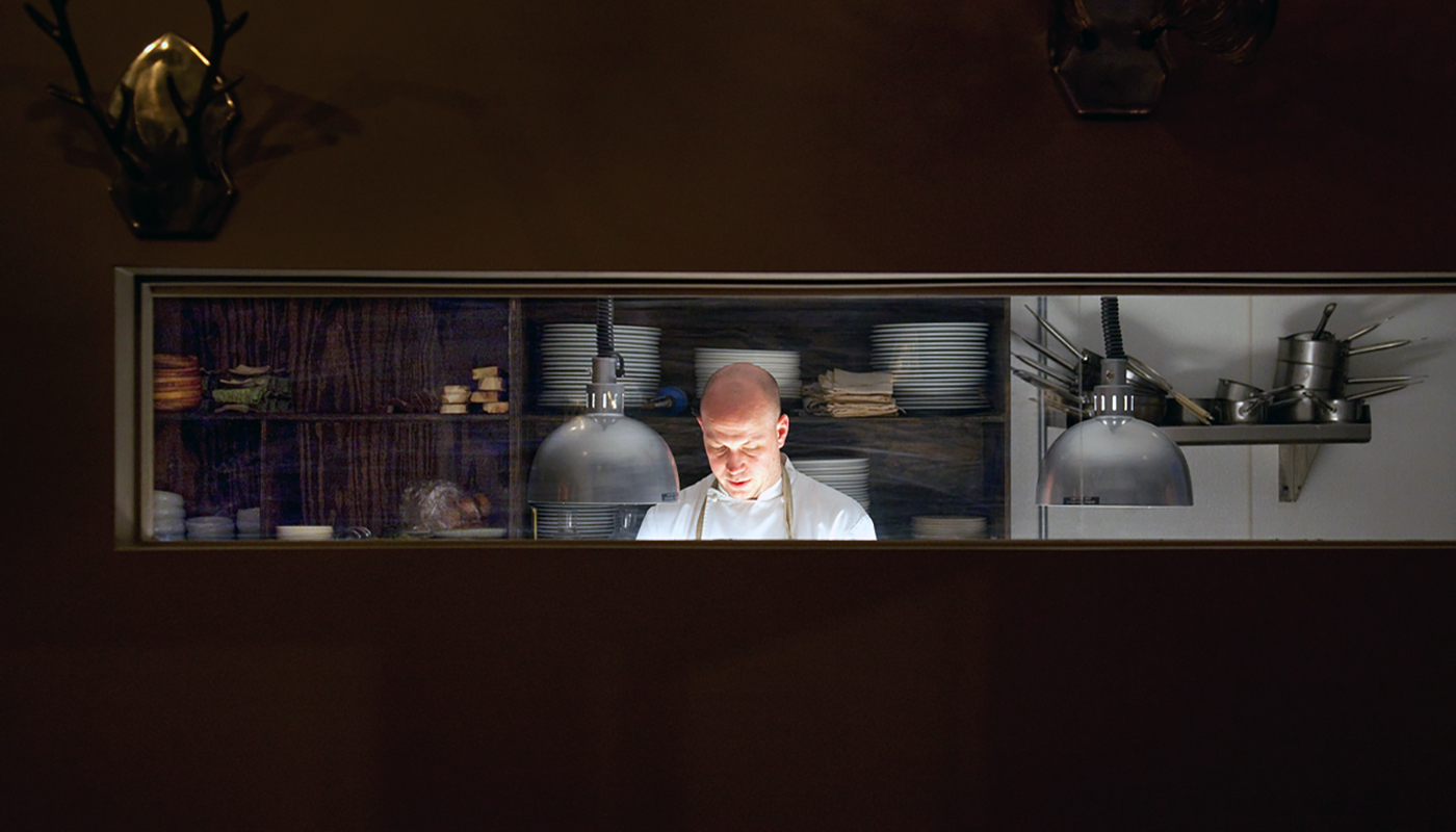 View of chef through kitchen window at Ardent restaurant