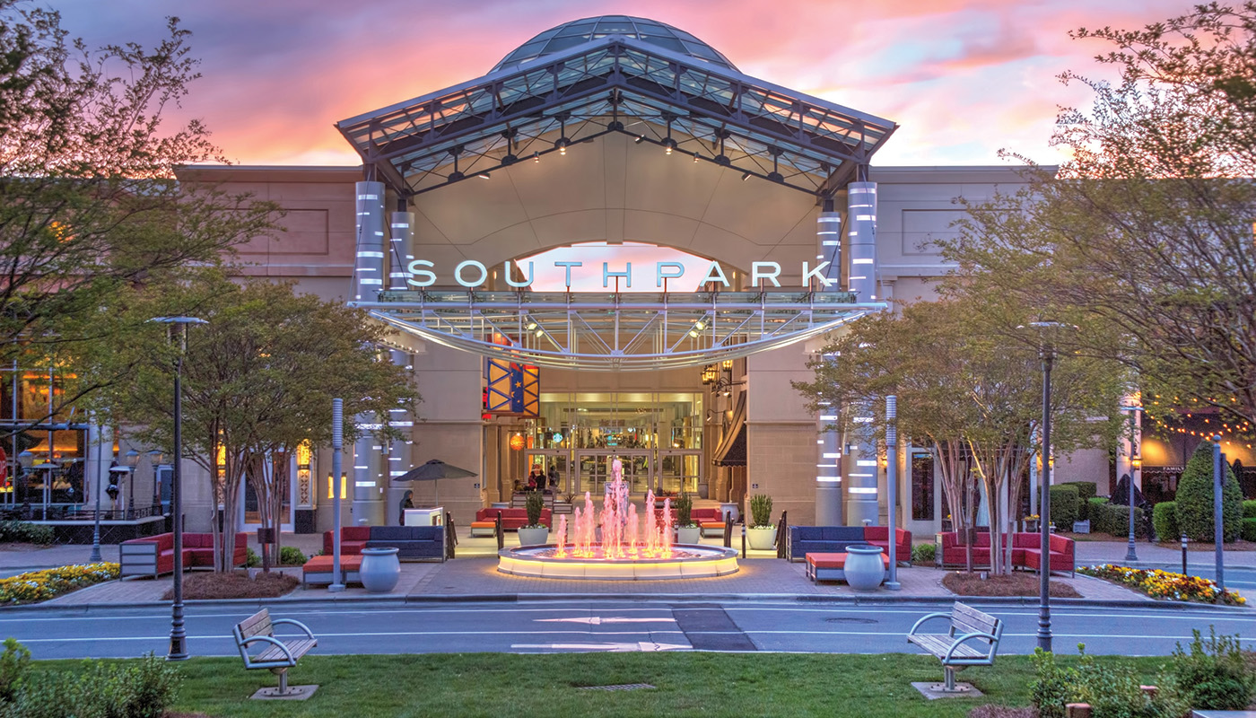 Exterior of SouthPark Mall at dusk with trees in foreground