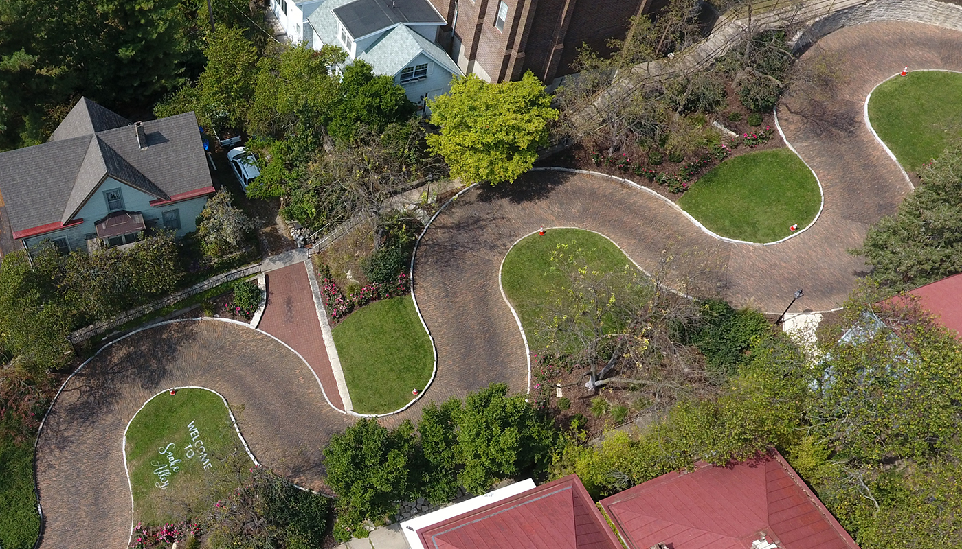 Aerial view of a winding road in the middle of a residential and commercial district.