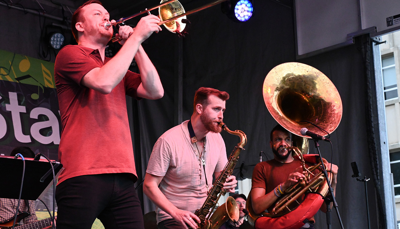 Three musicians play the trombone, saxophone and French horn during the Iowa City Jazz Festival.