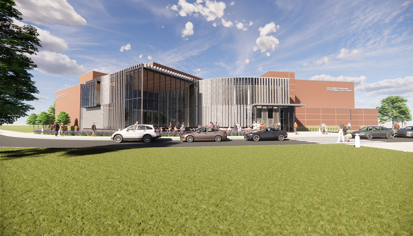 Exterior view of performing arts center with cars and grass in foreground