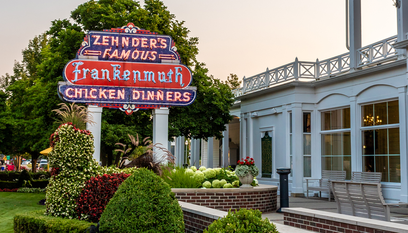 A neon sign reads, “Zehnder’s Famous Frankenmuth Chicken Dinners” outside the restaurant.