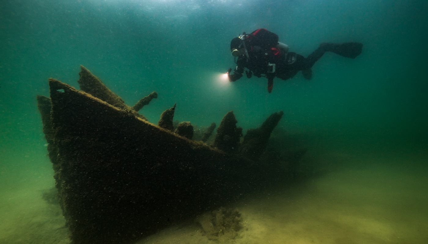 A scuba diver explores a shipwreck. 