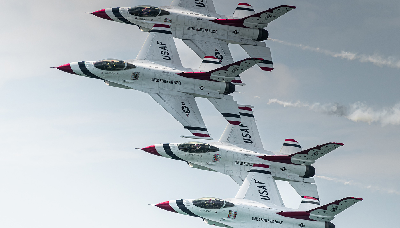Several U.S. Air Force Thunderbirds performing maneuvers and flying in the sky.