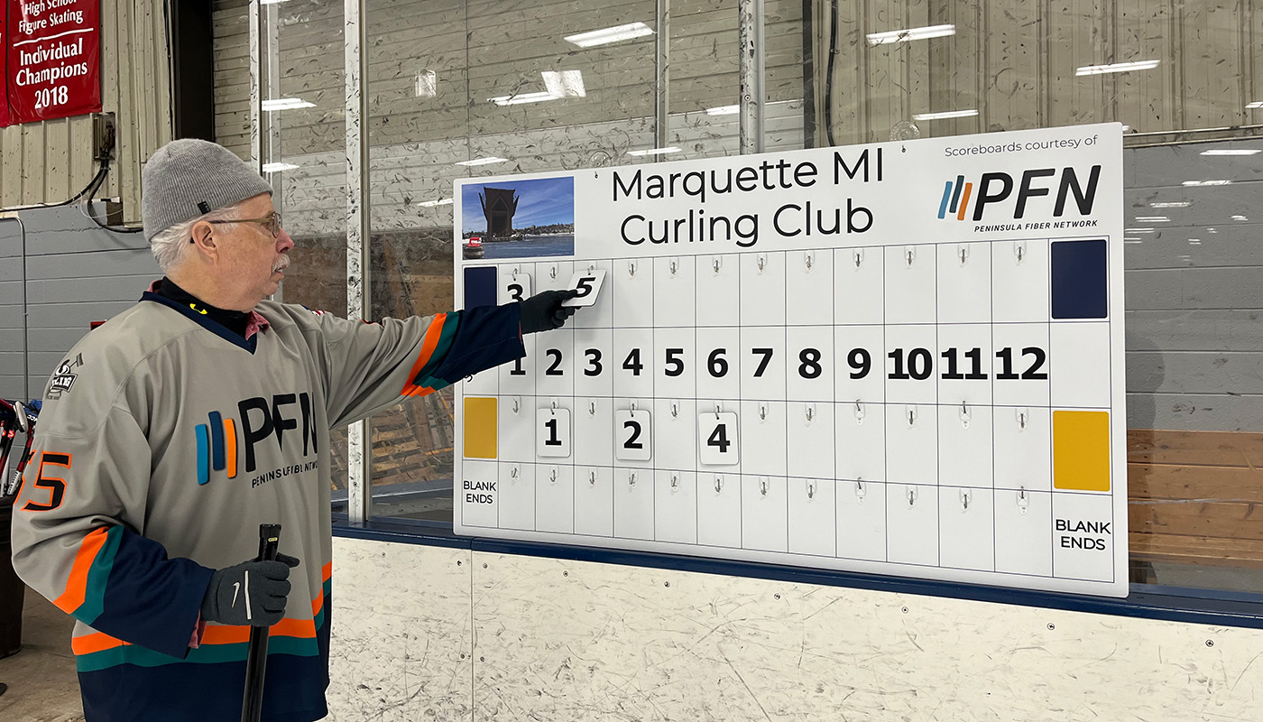 Man keeping score on a scoreboard durring a curling game