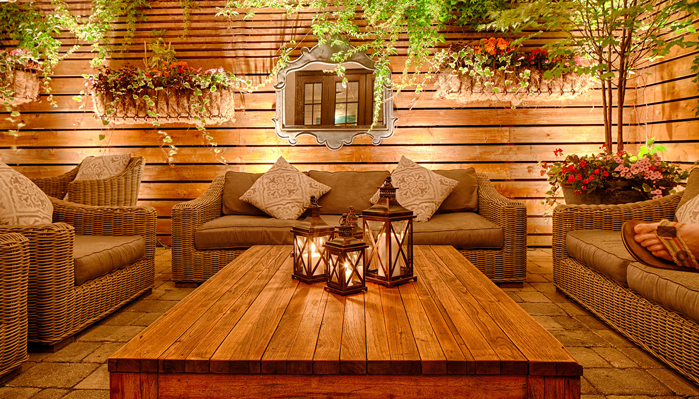 Softly lit outdoor patio with seating, table and plants