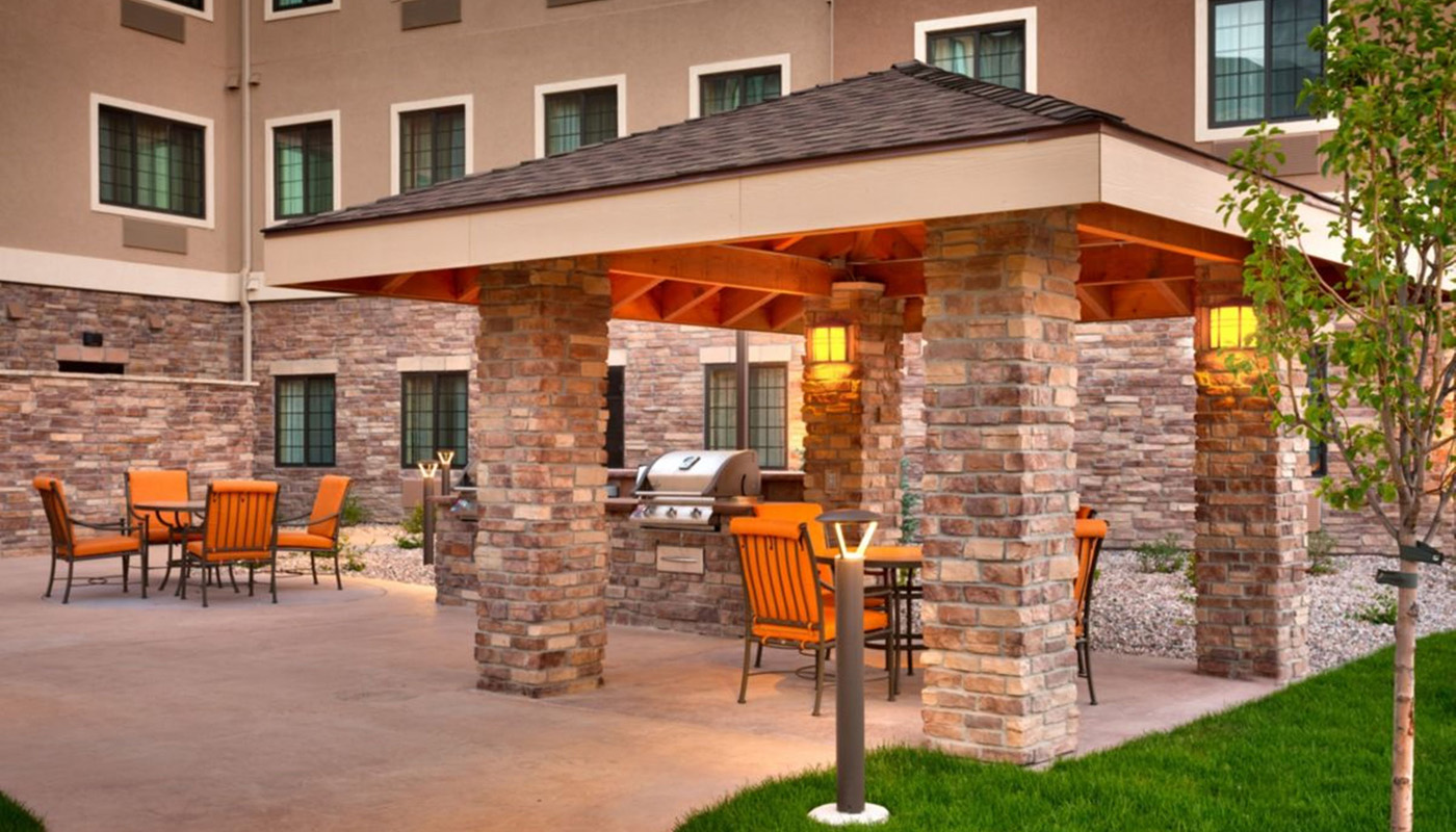 Outdoor patio with pergola, tables and chairs, and a grill