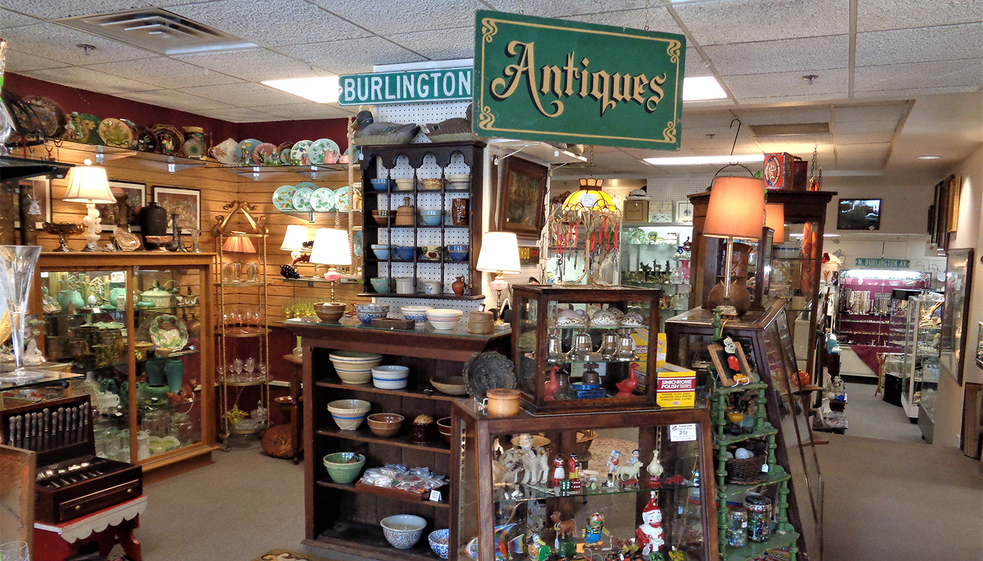 Shop shelves filled with antiques such as china, silverware, pottery and more.                                