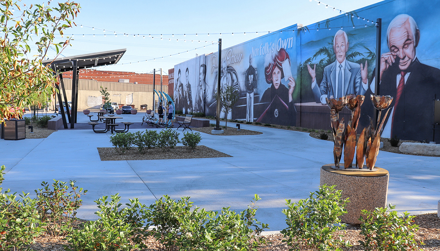Street view of the Johnny Carson mural with various plants, lights and a sitting area in the foreground