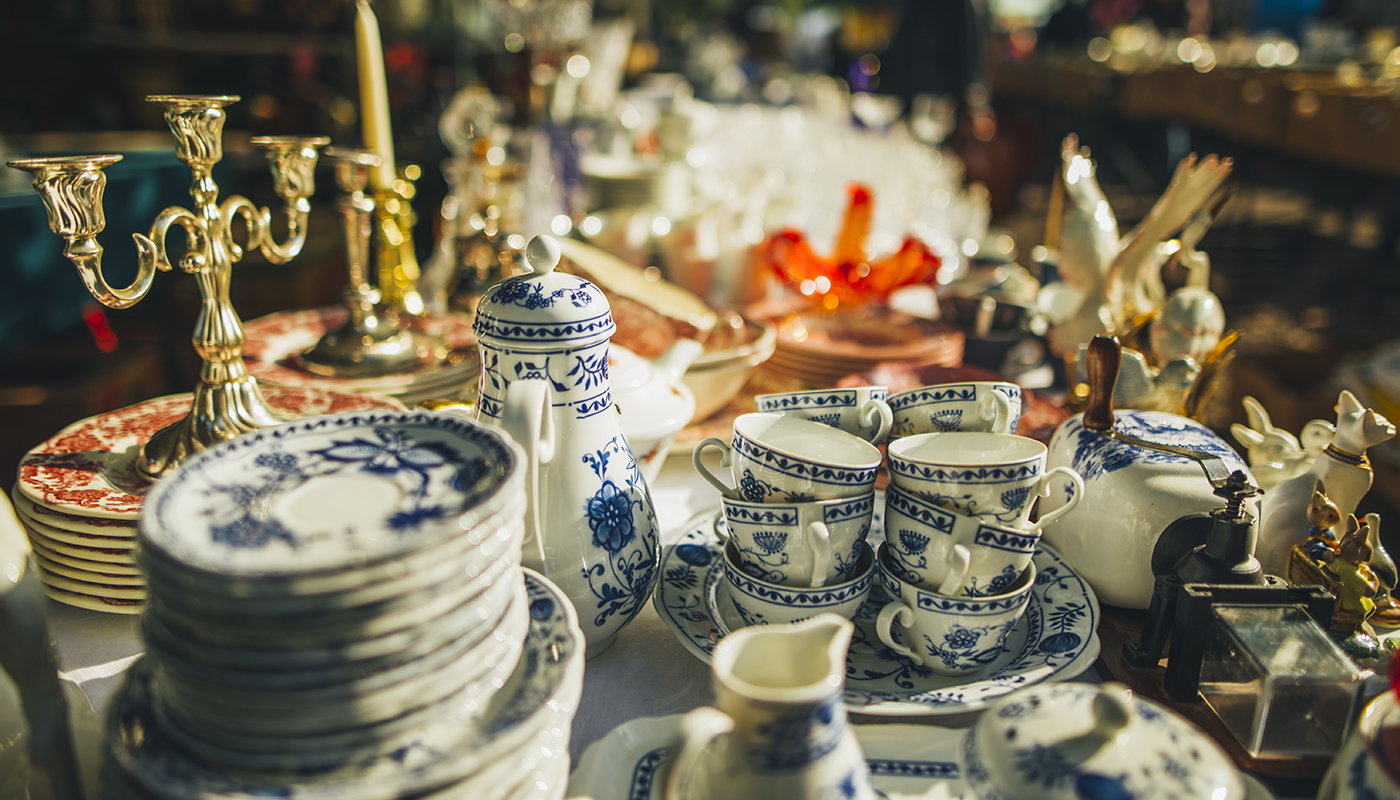 A table filled with antique blue and white china and candelabras. 