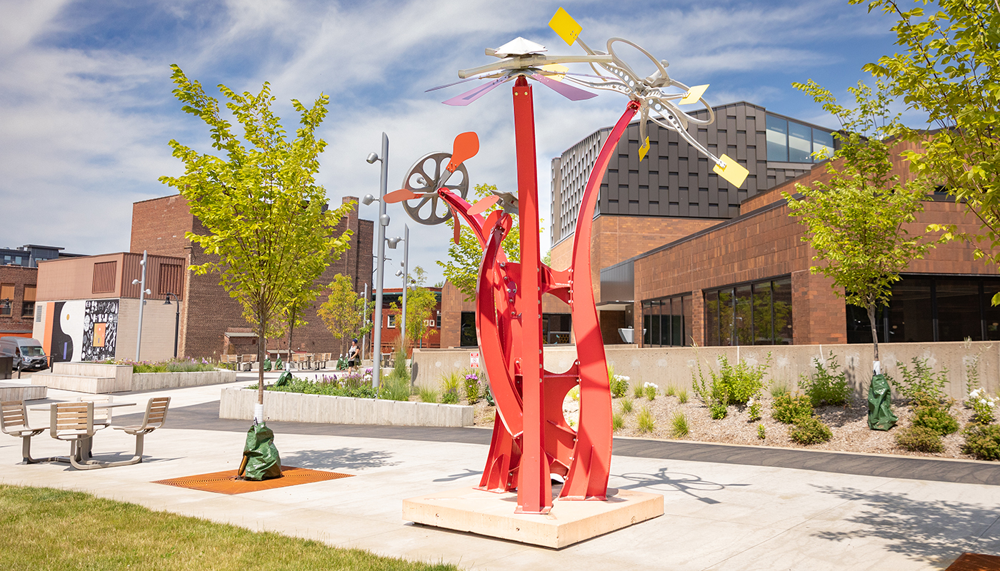 A red, twisting outdoor sculpture resembles three flowers.