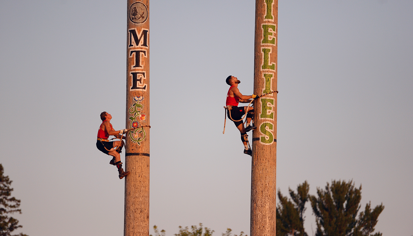 Two Lumberjack World Championships athletes compete in the speed pole climbing event.