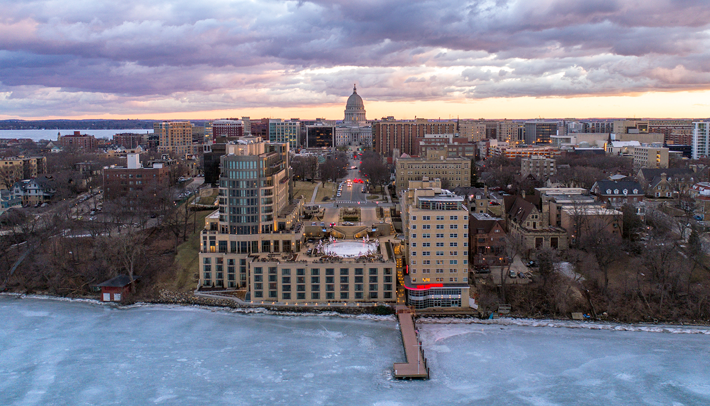 Aerial view of The Edgewater Hotel next to frozen Lake Mendota at sunset on a cloudy evening