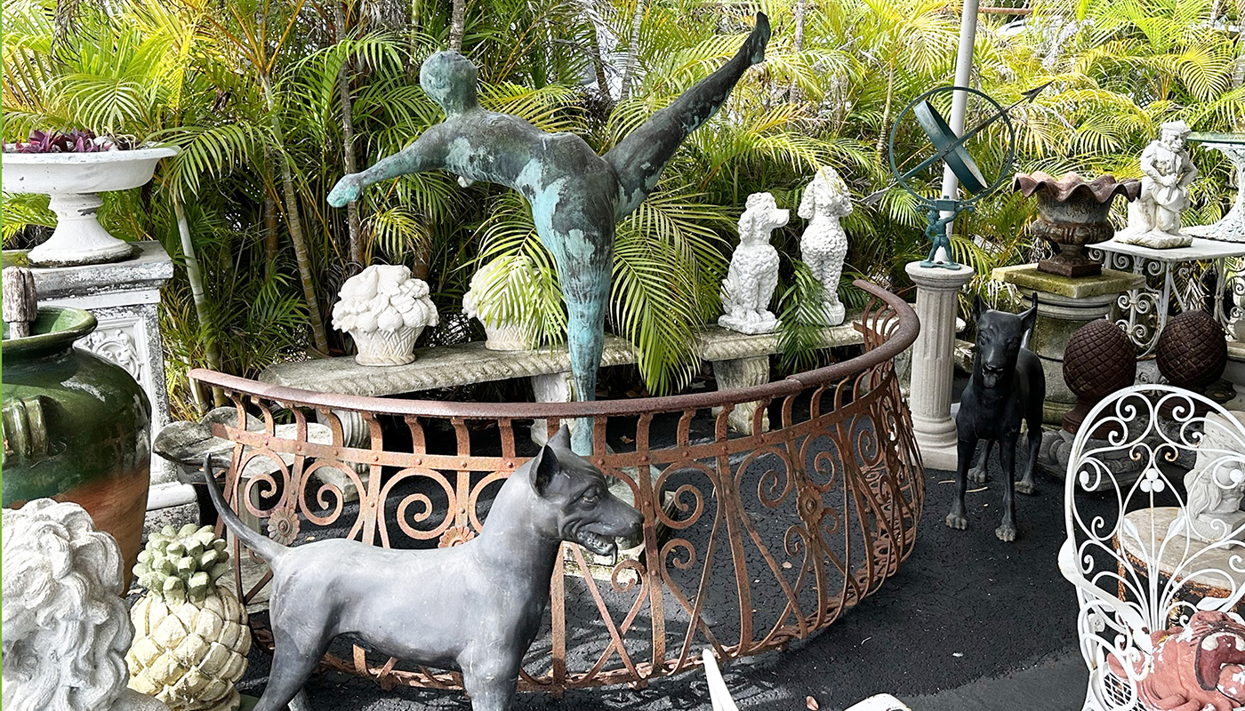 A collection of antique statues, including a dancer, dogs and pineapples. 