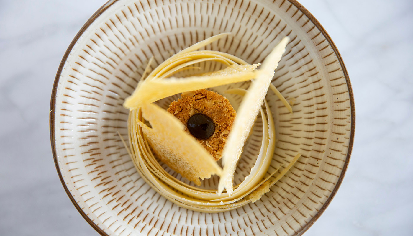 Overhead view of parmesan shavings served in a patterned bowl