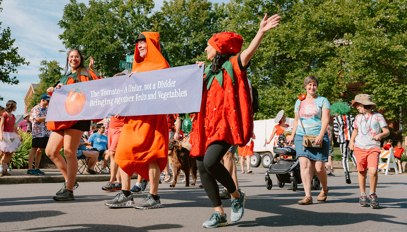 Revelers dressed in tomato costumes lead the parade during the Tomato Art Fest in Five Points.