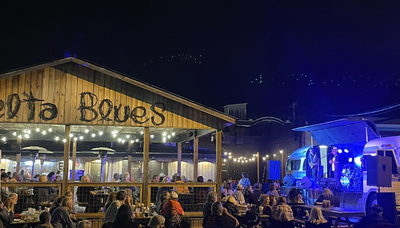 Exterior view of Delta Blues at night with patrons and live music performers