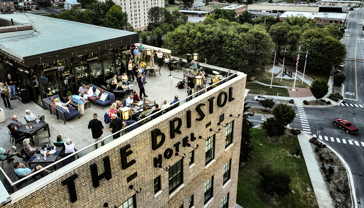Aerial view  of The Bristol Hotel's rooftop bar with patrons enjoying the view