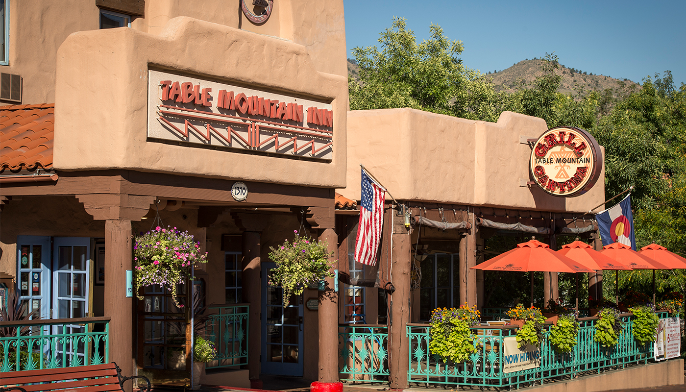 Exterior view of Table Mountain Inn, built in Southwestern adobe-style. The Table Mountain Grill and Cantina and its outdoor dining area is beside it.