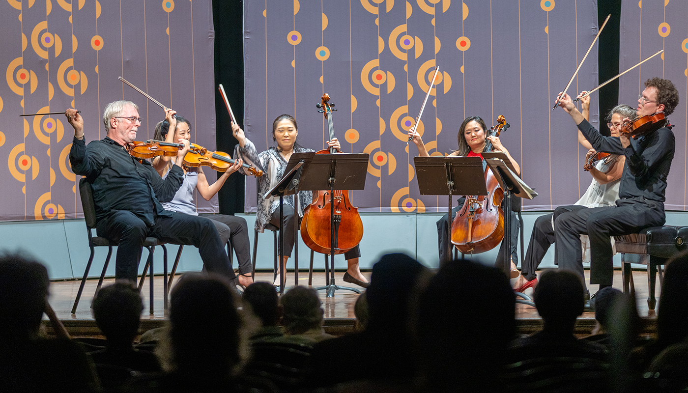 A sextet playing various stringed instruments performs during the Colorado Music Festival.