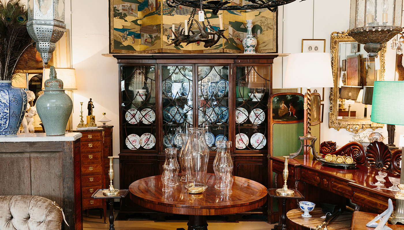 An antique display of china, vases, chandeliers, tables and shelves. 