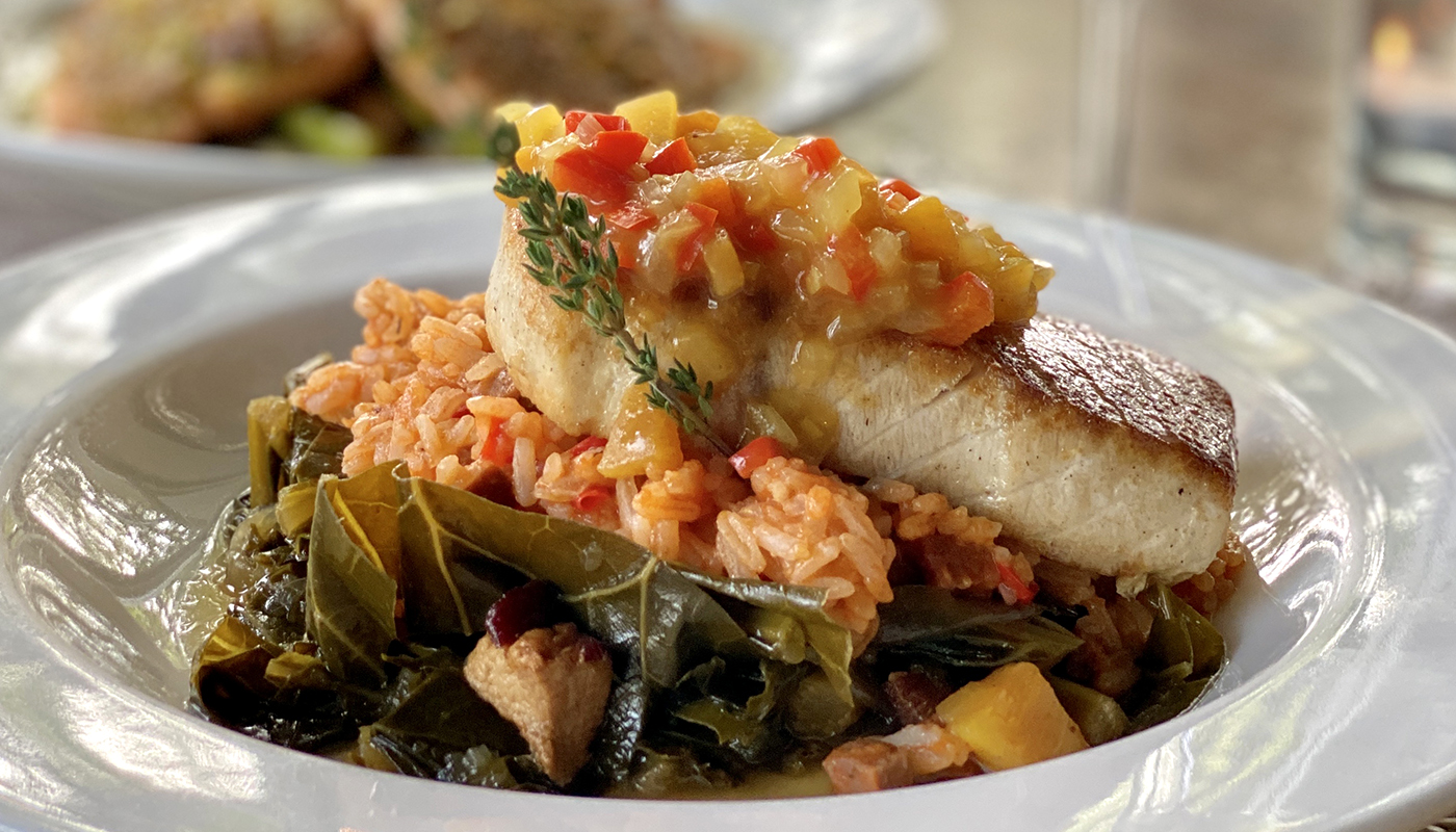 Braised swordfish topped by peach chutney served over andouille red rice and collard greens.