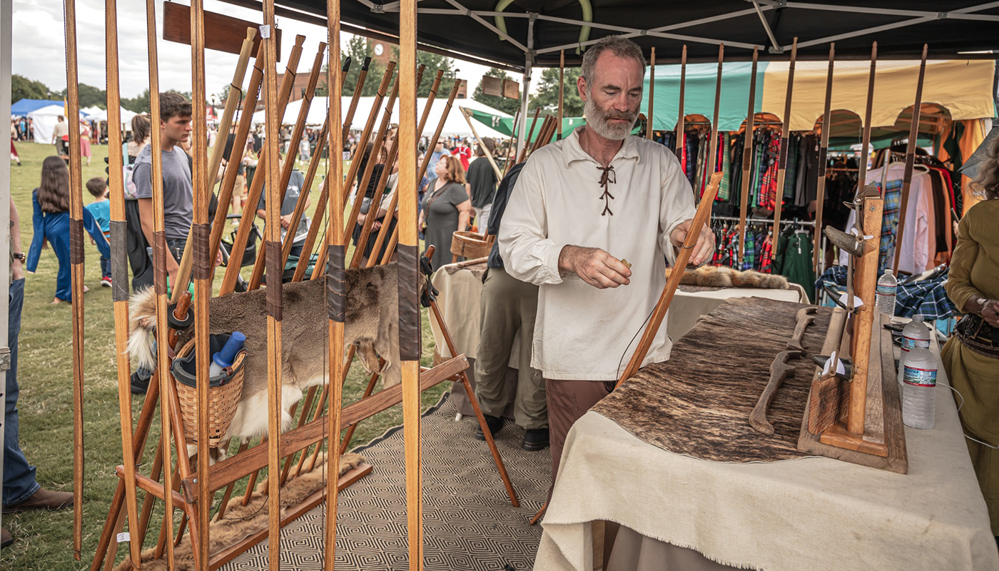 A man in medieval garb sells handcrafted goods during the Upstate Renaissance Faire.